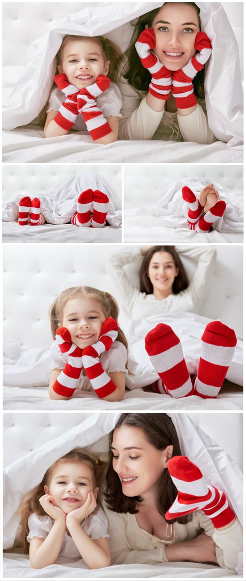 Cheerful little daughter and mom on bed stock photo